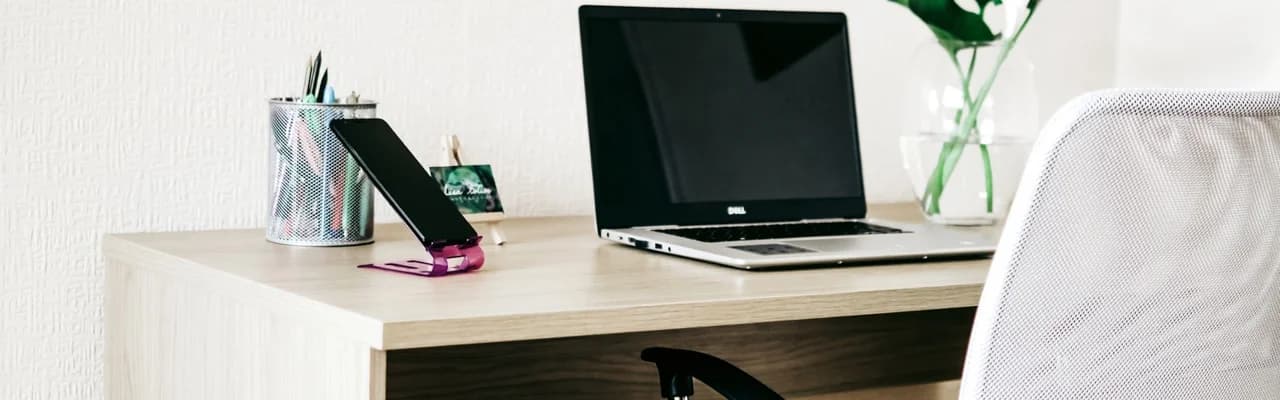 Laptop és telefon egy fa íróasztalon